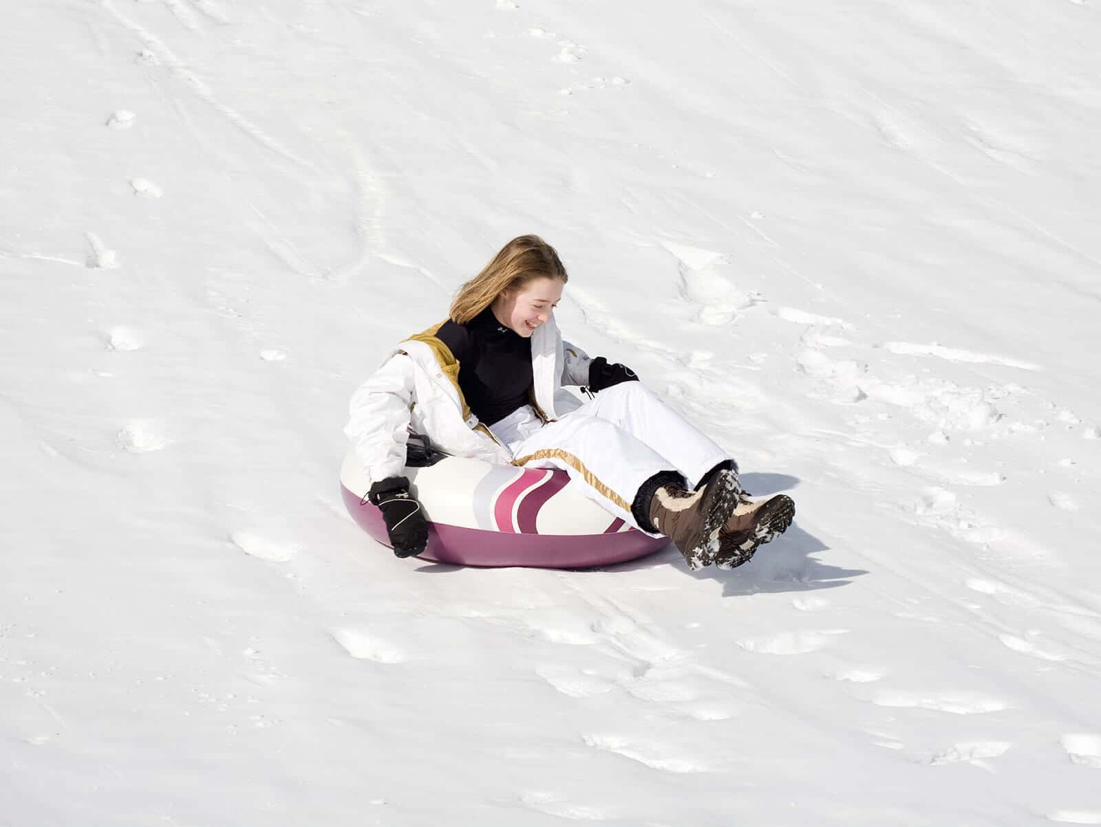 Young girl sledding down a hill