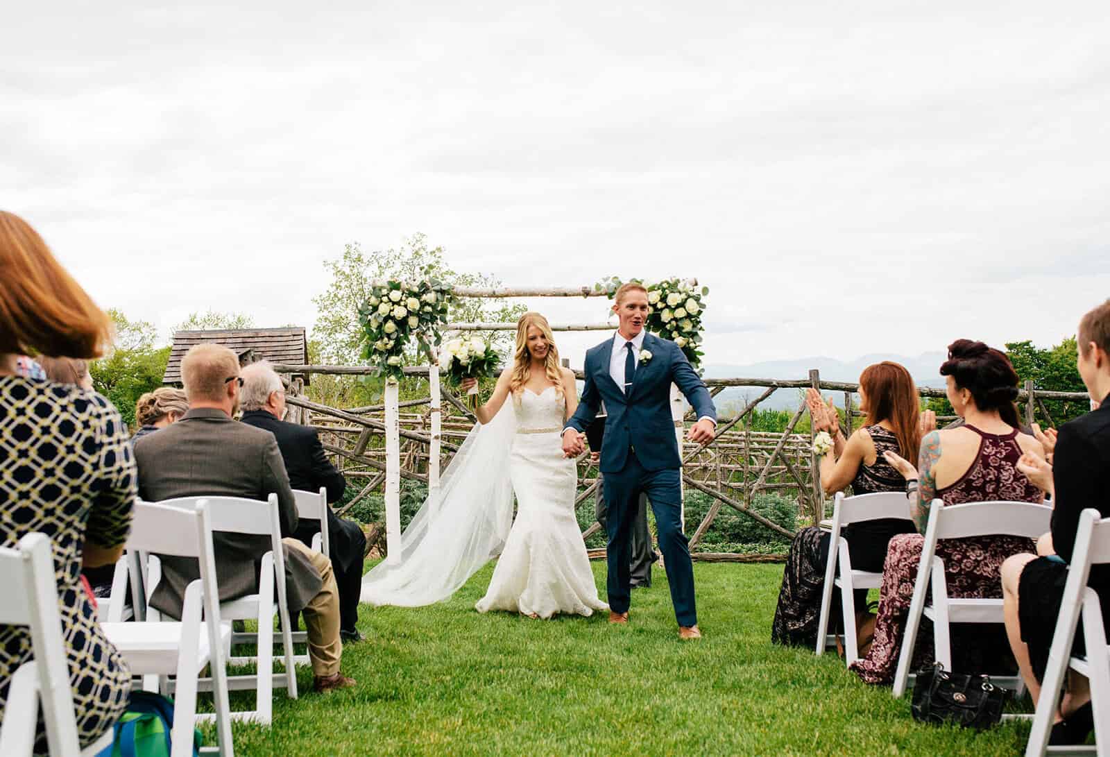 Couple walking down the aisle with mountains in background