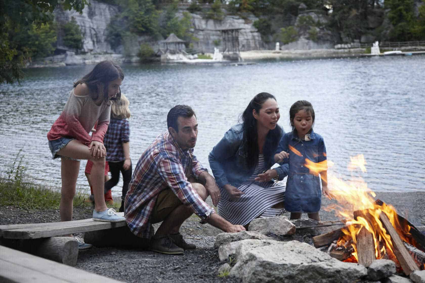 Family roasting marshmallows over campfire near Lake Mohonk