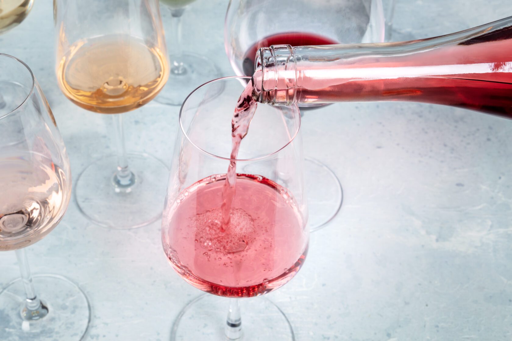Rose wine poured into a glass at a tasting at a winery, with copy space. Winetasting event