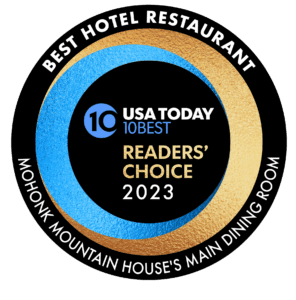 Circular logo that displays in the middle USA Today 10 BEST READERS' CHOICE 2023. Around the outside it states Best Hotel Restaraunt Mohonk Mountain Houses Main Dining Room