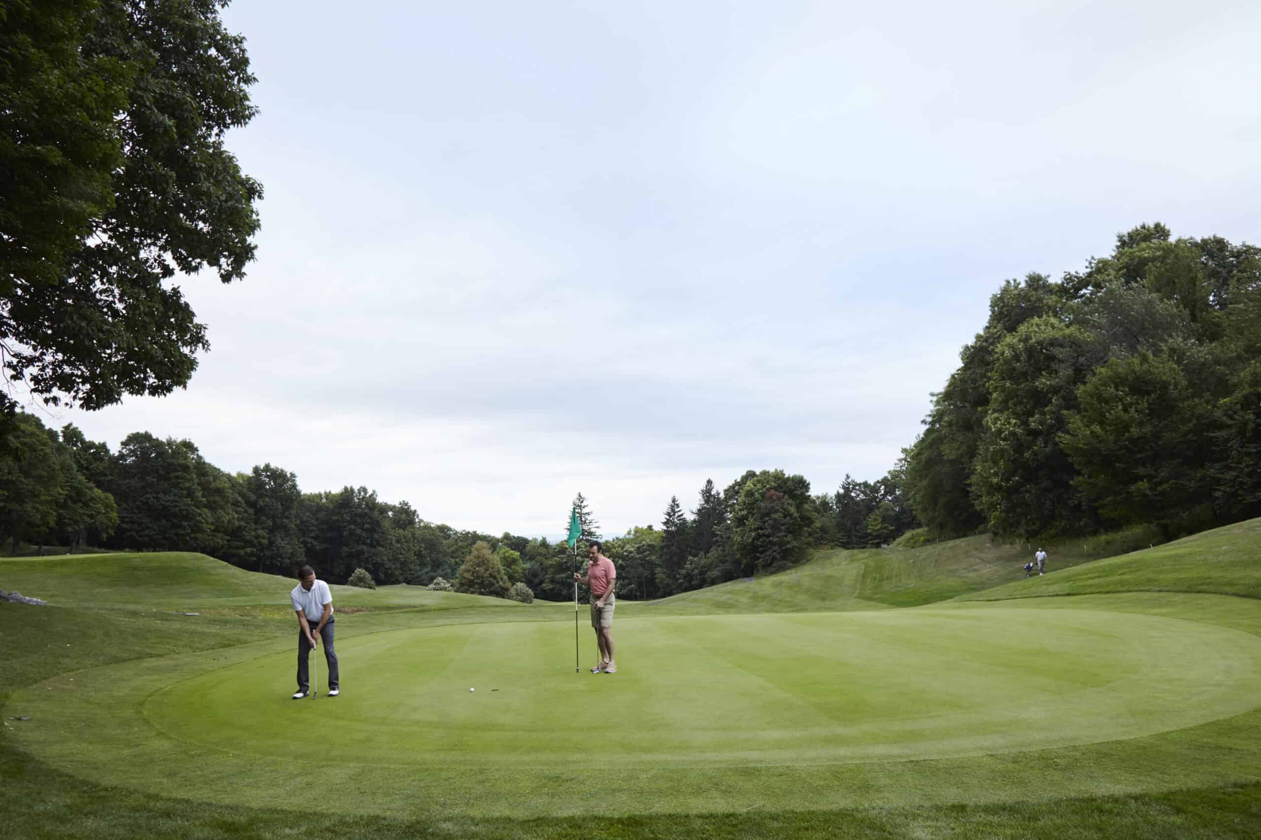 Two men putting on the green at Mohonk Mountain House golf course
